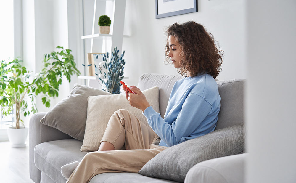 young female on sofa with phone